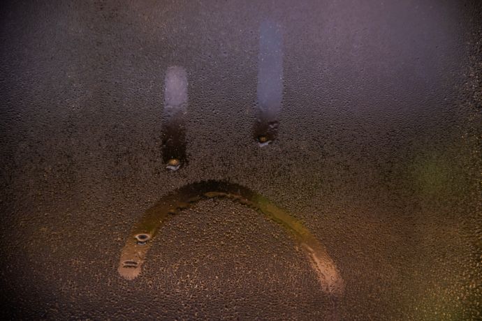 Condensation sur la fenÃªtre avec le dessin dâ€™un smiley triste. 