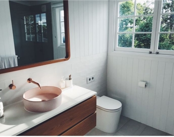 Salle de bains blanche avec lavabo rose et reflets marron foncÃ© 