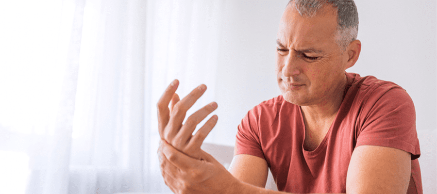 Mann leidet an rheumatisch bedingten Schmerzen in den Händen